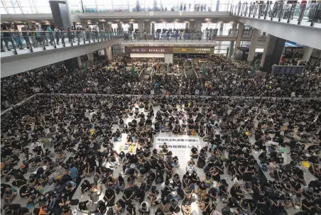  ?? Vincent Thian / Associated Press ?? Protesters join a sitin rally at the arrivals hall of the Hong Kong Internatio­nal Airport. More than 150 flights were canceled.