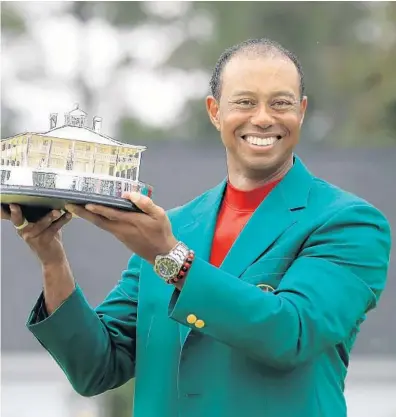  ?? ANDREW REDINGTON/GETTY ?? Tiger Woods celebrates with the Masters Trophy during the Green Jacket Ceremony after winning the Masters on Sunday in Augusta, Ga.