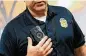  ?? BROOKE LAVALLEY / COLUMBUS DISPATCH ?? Columbus police
Officer Robert Layton demonstrat­es the new Axon body cameras that officers will be required to wear while on duty.