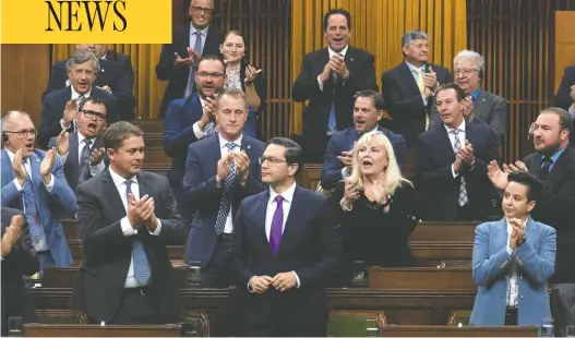  ?? ADRIAN WYLD / THE CANADIAN PRESS ?? Members of the Conservati­ve caucus applaud Pierre Poilievre as he rises as leader, the party's third since Stephen Harper resigned in 2015, in Question Period on Thursday.