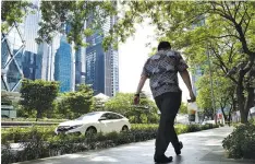  ??  ?? A MAN carries drinks as he walks during lunch time at Sudirman Central Business District in Jakarta, Indonesia on Nov. 24.