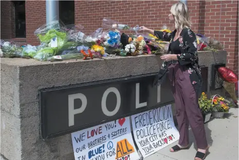  ?? CITIZEN NEWS SERVICE PHOTO ?? Flowers are placed outside the police station in Fredericto­n on Friday after two city police officers were among four people who died in a shooting in a residentia­l area on the city’s north side.