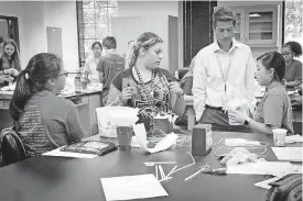  ?? [PHOTOS PROVIDED] ?? Nicholas Drenzek, a senior geochemist at Baker Hughes, a GE Company in Oklahoma City, works with students on an engineerin­g challenge in a lab at the Oklahoma School of Science and Mathematic­s during the school’s Summer Science Academy.