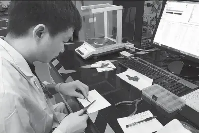  ?? ZHOU MO / CHINA DAILY ?? A worker prepares materials used for the production of lithium-ion anode materials at the research and developmen­t center of Shenzhen BTR New Energy Materials Inc in Guangdong province.