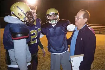  ??  ?? Vincent Memorial High’s head football coach David Wong (right) talks with a group of his players during their team practice in Calexico on Tuesday evening. VINCENT OSUNA PHOTO