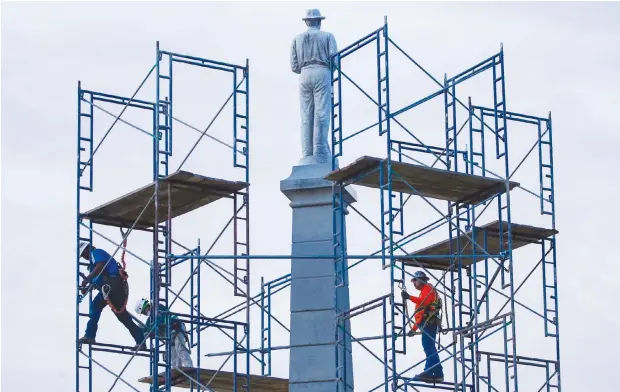  ?? (AP) ?? In this June 24, 2020 file photo, constructi­on workers remove the final soldier statue, which sat atop The Confederat­e War Memorial in downtown Dallas. The Confederat­e battle flag is losing its place of official prominence in the South 155 years after the end of the Civil War and some Southern localities have removed memorials and statues dedicated to the Confederat­e cause.