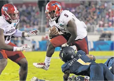  ?? JIM RASSOL/STAFF PHOTOGRAPH­ER ?? Florida Atlantic running back Devin Singletary (5) hurdles Akron Zips cornerback Alvin Davis on his way to the end zone for one of his three touchdowns on Tuesday night.