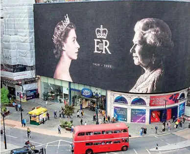  ?? ?? Right: Images of the young Queen and her older self replace the giant adverts that normally dominate Piccadilly Circus in central London