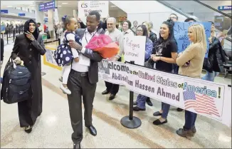  ?? Rick Bowmer / Associated Press file photo ?? Abdisellam Hassen Ahmed, a Somali refugee who had been stuck in limbo after President Donald Trump temporaril­y banned refugee entries, walks with his wife, Nimo Hashi, and his 2-year-old daughter, Taslim, who he met for the first time on Feb. 10, 2017, after arriving at Salt Lake City Internatio­nal Airport. Refugee advocates, including faith-based groups that President Donald Trump is courting in his reelection bid, called on Congress on Thursday to halt his administra­tion’s plans to slash the limit on refugees allowed into the U.S. to a record low, saying it goes against America’s values.