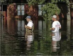  ?? GERRY BROOME — THE ASSOCIATED PRESS ?? Residents walk through a flooded neighborho­od in Lumberton, N.C., Monday in the aftermath of Hurricane Florence.