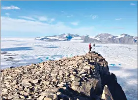  ??  ?? This July 2015 photo taken by University of Ottawa glaciology professor Luke Copland shows Canadian Ice Service ice analyst Adrienne White taking a photo of cracks of the Milne Ice Shelf, which just broke apart. The Milne was on of the Arctic’s few remaining intact ice shelves, but at the end of July about 43% broke off. Scientists say that without a doubt it’s man-made global warming. (Luke Copland via AP)