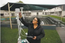  ?? Liz Hafalia / The Chronicle ?? Air quality instrument specialist Ila Perkins checks a monitor to measure fine-particle pollution at John B. Riebli Elementary School in Santa Rosa.