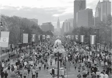  ??  ?? Runners make their way down Benjamin Franklin Parkway during the 2012 Philadelph­ia Marathon. For every 100 people suffering a heart attack or cardiac arrest, three to four more died within a month if they had sought care on a marathon day versus...