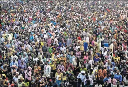  ??  ?? Mass worship: Eyo masquerade­rs (top) entertain the crowd at the Tafawa Balewa Square in Lagos. Worshipper­s attend a service at the Living Faith Church (left), also known as the Winners’ Chapel, in Ota district, Ogun state and Muslims (left) at...