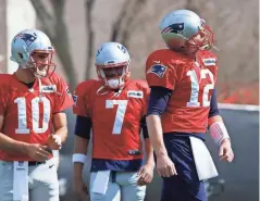  ?? GETTY IMAGES ?? Reserve quarterbac­ks Jimmy Garoppolo (left) and Jacoby Brissett (center) look on as Tom Brady works out during a Super Bowl practice session.