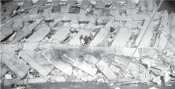  ??  ?? Rescuers enter a building that collapsed on its side when an earthquake struck the southern Taiwan city of Tainan, population 1.8 million.