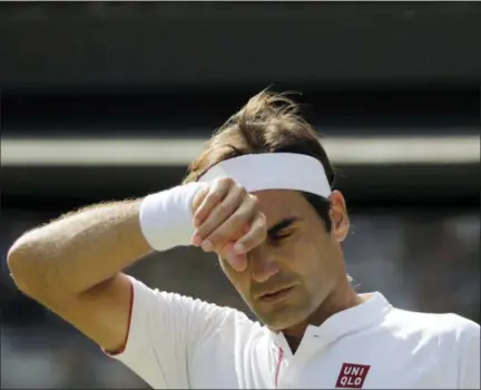  ?? BEN CURTIS — THE ASSOCIATED PRESS ?? Switzerlan­d’s Roger Federer wipes his forehead during the fifth set of his men’s quarterfin­als match against Kevin Anderson of South Africa at the Wimbledon Tennis Championsh­ips, in London, Wednesday.