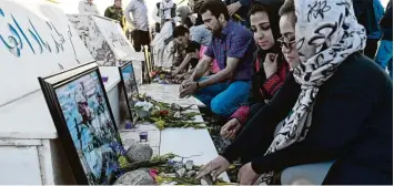  ?? Foto: W. Kohsar, afp ?? Afghanen legen an einer Gedenkstät­te in Kabul Blumen für die Opfer des Massakers ab.