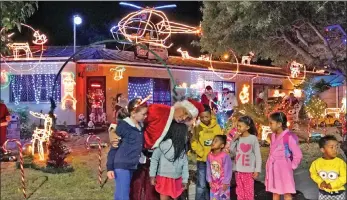  ?? PICTURE: IAN LANDSBERG/AFRICAN NEWS AGENCY/ANA ?? Children flock to ‘Santa’ Gerry Smeda’s Christmas house to watch the switch-on of the festive lights at his home in Muller Street, Kuils River, keeping with his charitable tradition. See page 5