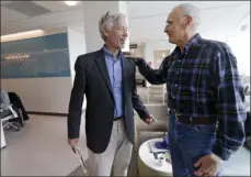  ?? AP PHOTO ?? In this photo taken March 29 Dr. David Maloney of the Fred Hutchinson Cancer Research Center is greeted by patient Ken Shefveland, whose lymphoma was successful­ly treated with CAR-T cell therapy.