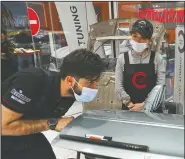  ??  ?? Deravi watches Tehran. a man repair a car door at a detailing shop in