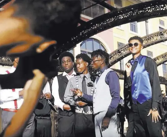  ?? Rachel Aston Las Vegas Review-Journal ?? D’Andre Burnett, far right, a senior at Shadow Ridge High School, takes pictures for homecoming with his friends at Tivoli Village.