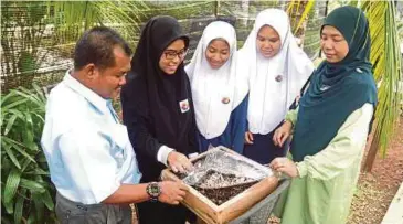  ??  ?? Pelajar dan guru SMK Sungai Soi melihat sarang lebah kelulut yang diternak di sekolah berkenaan sejak 2015 lagi.