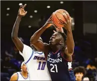  ?? Charles Rex Arbogast / Associated Press ?? UConn’s Adama Sanogo (21) looks to the basket as DePaul’s Yor Anei defends during the first half on Jan. 29 in Chicago.