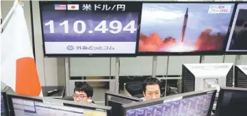  ??  ?? Employees of a foreign exchange trading company work in front of monitors showing TV news on North Korea’s threat (right) and the Japanese yen’s exchange rate against the US dollar (left) in Tokyo, Japan. — Reuters photo