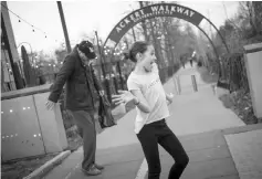  ??  ?? A young girl and man dance to music by Chuck Berry outside the statue of Chuck Berry on Mar 19 in University City, Missouri.