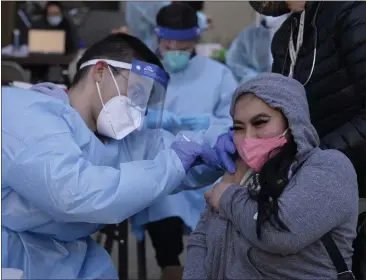  ?? PHOTOS BY SHERRY LAVARS — MARIN INDEPENDEN­T JOURNAL ?? Marin County Health Clinics nurse Diego Navarro gives The Tamalpas employee Angelene Tingzon a Pfizer COVID-19 vaccinatio­n shot at The Tamalpais in Greenbrae on Thursday.