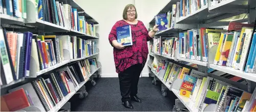  ?? PHOTO: PETER MCINTOSH ?? Nothing like a good book . . . CCS Disability Action librarian Krissy Wright has had a busy start to the year preparing the new Dunedinbas­ed library for the service.