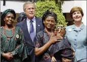  ?? (AP/J. Scott Applewhite) ?? Then-President George W. Bush and Laura Bush pose with mothers affected by AIDS and their HIV-free children in Abuja, Nigeria, in July 2003.