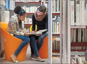  ??  ?? Une étudiante bénévole de l’Afev aide une collégienn­e pour ses devoirs.