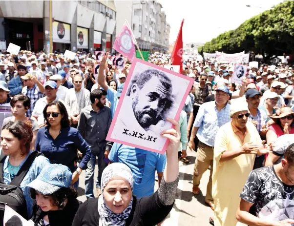  ??  ?? A protester holds a portrait of protest movement leader Nasser Zefzafi and shouts slogans during a demonstrat­ion against corruption and official abuses in the Rif region in Rabat, Morocco on Sunday. (Reuters)