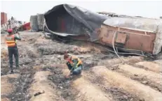 ?? FOTO: AP ?? QQ Rescatista­s examinan la autopista donde explotó el camión.