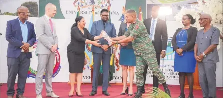  ?? ?? The award being presented to UG Vice Chancellor, Dr Paloma Mohamed by Chief of Staff of the Guyana Dafence Force, Omar Khan. President Irfaan Ali is fourth from left. (Office of the President photo)