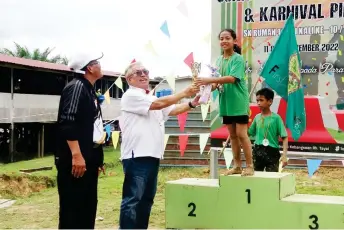  ?? — Sarawak Public Communicat­ions Unit photo ?? Sikie presents a trophy to an event winner.