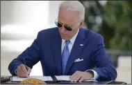  ?? (AP/Evan Vucci) ?? President Joe Biden signs two bills aimed at combating fraud in the covid-19 small business relief programs Friday at the White House in Washington.