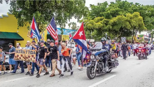  ?? PEDRO PORTAL pportal@miamiheral­d.com ?? Cuban Americans march along Southwest Eighth Street on Friday.