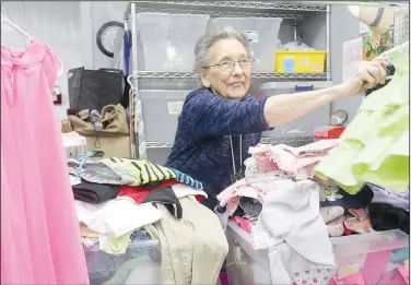  ?? (NWA Democrat-Gazette/Lynn Kutter) ?? Volunteer Dorothy Posey of Prairie Grove sorts through spring clothes to put out on the floor at the LIFE Ministries resale store in Prairie Grove.