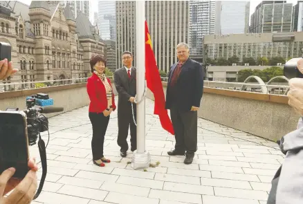  ?? JACK BOLAND / POSTMEDIA NEWS ?? Consul General for China Han Tao, centre, and Toronto city councillor­s Cynthia Lai and Jim Karygianni­s attend the People’s Republic of China flag-raising ceremony at Toronto City Hall last week. Toronto Mayor John Tory refused to take part, citing tensions between the two countries.