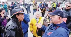  ?? | MARK DUNCAN/ AP ?? Philip Yenyo ( left), executive director of the American Indians Movement for Ohio, talks with a Cleveland Indians fan before a baseball game in Cleveland in 2015.