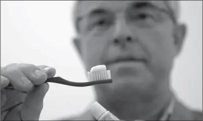  ?? The Associated Press ?? TOOTHBRUSH­ING: In this photo taken Friday Philippe Hujoel, a dentist and University of Washington professor, holds a toothbrush and toothpaste as he poses for a photo in an office at the school in Seattle. Dental health experts worry that more people are using toothpaste that skips the most important ingredient - the fluoride - and leaves them at a greater risk of cavities.