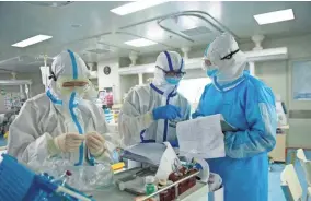 ?? STR/AFP VIA GETTY IMAGES ?? Medical staff check notes at a hospital in Wuhan, China, on Feb. 22.