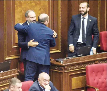  ?? — AFP photo ?? Pashinyan is greeted by a lawmaker after being elected as prime minister during a parliament session in Yerevan.