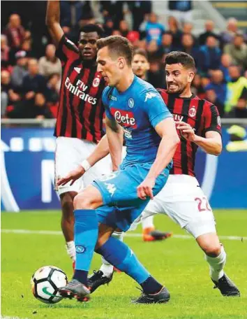  ?? AP ?? Napoli’s Arkadiusz Milik (centre) tries to score against AC Milan at the San Siro in Milan on Sunday. Gianluigi Donnarumma’s last-gasp save denied Napoli a win during the Serie A match.