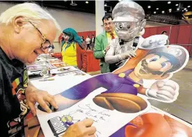  ?? Photos by Melissa Phillip / Staff photograph­er ?? Charles Martinet, the voice actor known for voicing Mario in the Super Mario video game series, signs an autograph for Ross Martinez, dressed as Metal Mario.