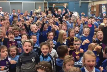  ??  ?? The silverware is held aloft as Diarmuid O’Keeffe visits his old primary school in Rathangan.