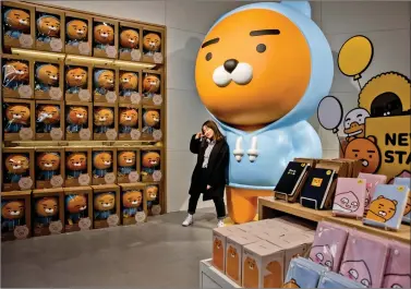  ?? AFP ?? A shopper poses for photos at a ‘Line’ store in Seoul on Thursday. ‘Line friends’ is the character unit of Line, the popular mobile messenger owned by Korean internet giant Naver.